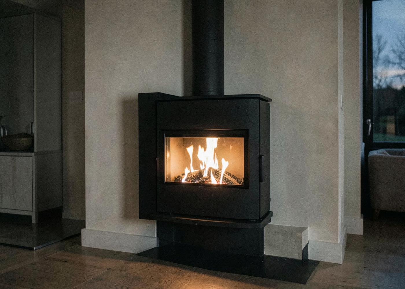 A modern ecodesign wood burning stove burning cleanly behind large clear glass